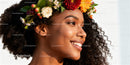 Smiling woman with natural curly hair wearing floral crown