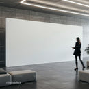 Woman walking past large blank white display in modern lobby