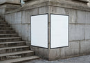 Blank double billboard on stone wall near stairs
