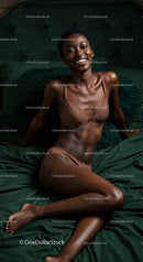 Smiling woman relaxing on dark green bed in lingerie