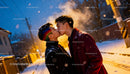 Young Asian couple sharing a kiss on snowy evening