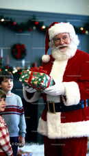 Santa Claus giving a Christmas gift to excited children