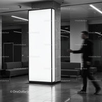 Blurred man walking past illuminated pillar in modern lobby