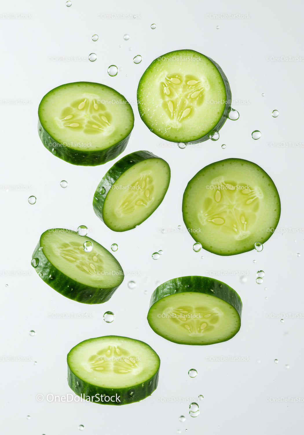 Fresh cucumber slices floating in clear water