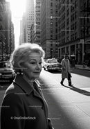 Elegant Elderly Woman Walking on City Street in Black and White