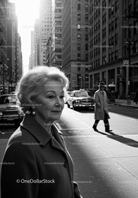 Elegant Elderly Woman Walking on City Street in Black and White