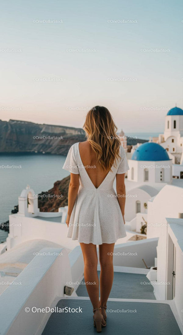 Woman in white dress overlooking Santorini sea view
