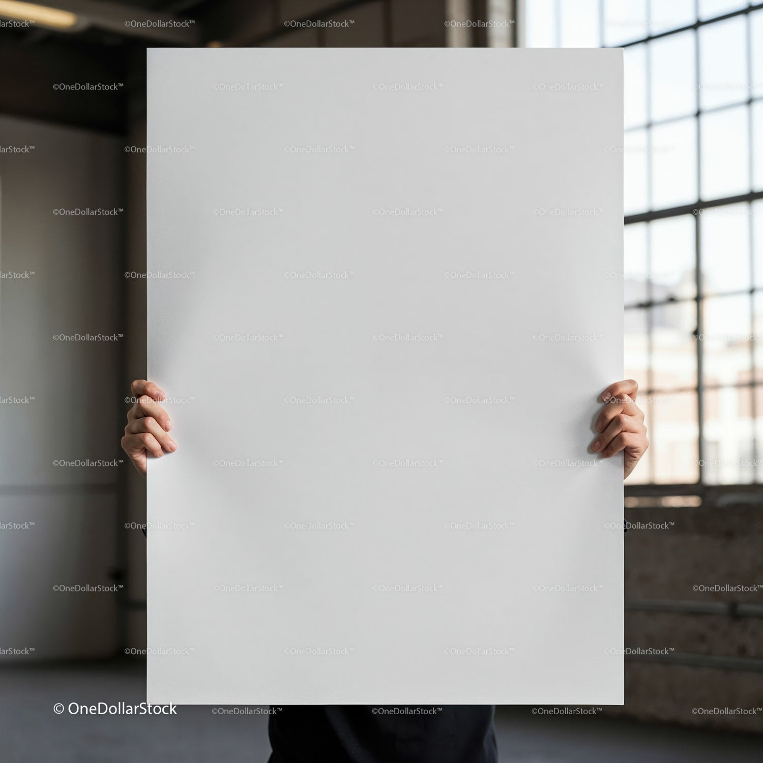 Person holding blank white poster in industrial space