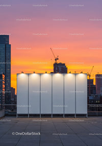 City Skyline with Modern Buildings and Construction Cranes at Sunset