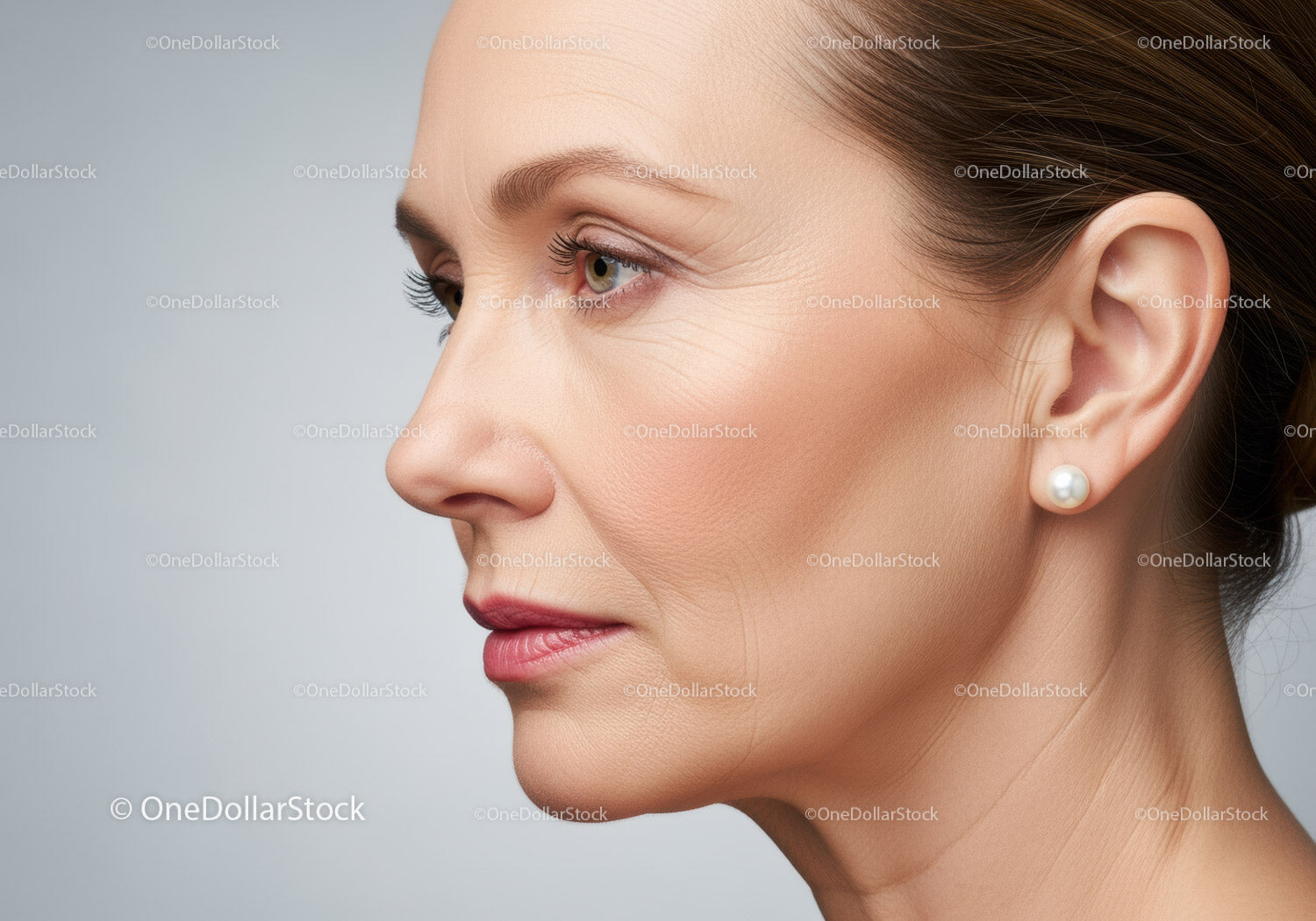 Elegant Woman with Pearl Earring and Smooth Skin in Side Profile