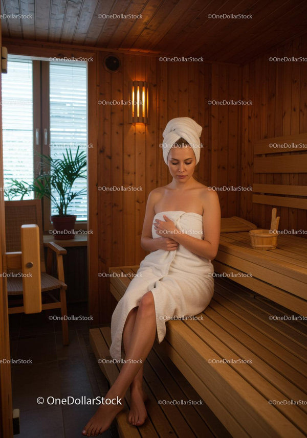 Relaksująca kobieta w drewnianej saunie w ręczniku Spa Wellness