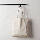 Plain canvas tote bag hanging on modern rack