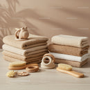 Stack of Soft Neutral Towels with Wooden Brushes and Toys