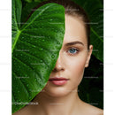 Close-up of Woman with Blue Eyes and Large Green Leaf with Water Droplets
