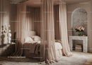 Elegant canopy bed with soft beige curtains and marble decor