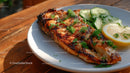 Grilled Fish with Cucumber Slices on Rustic Wooden Table