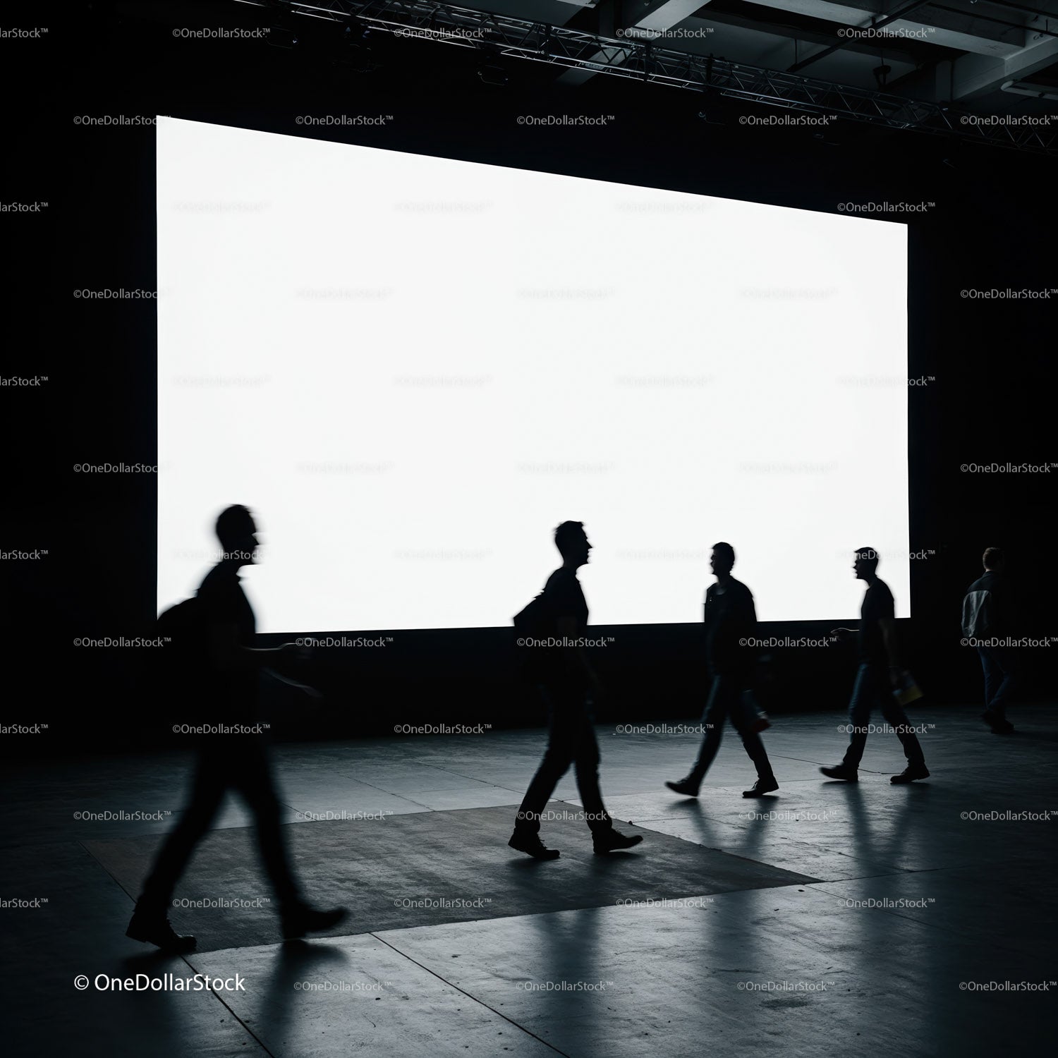 Silhouettes of people walking past a large blank screen