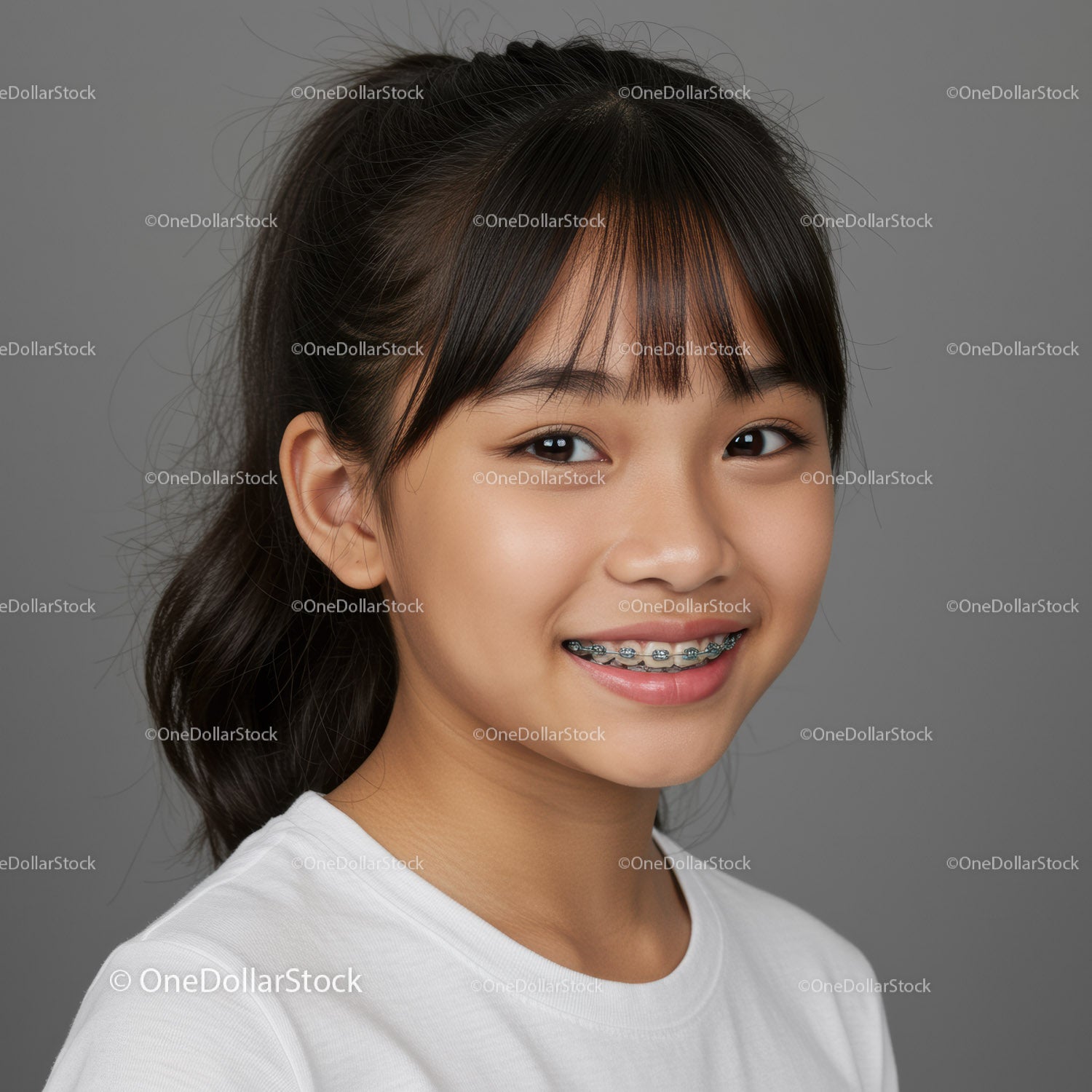 Young Girl with Braces Smiling Against Gray Background