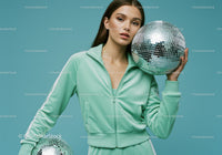 Young Woman in Mint Green Tracksuit Holding Disco Ball in Studio