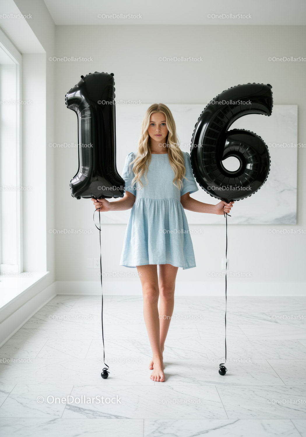 Teenage girl holding black 16 number balloons indoors