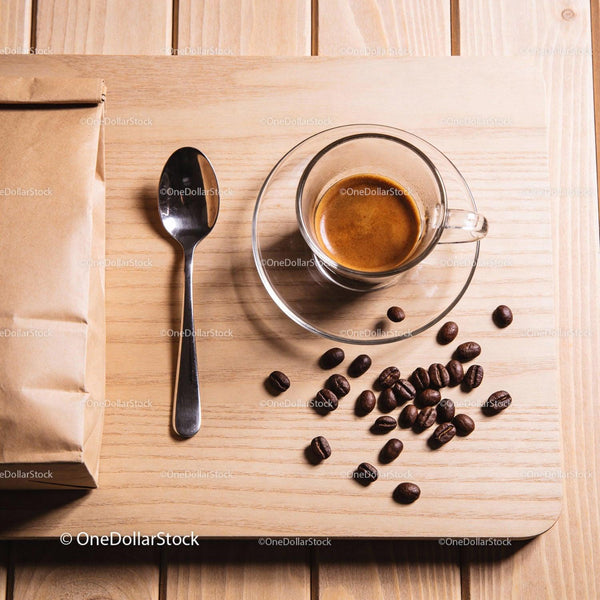 Freshly brewed espresso with coffee beans and spoon