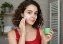 Young Woman Applying Face Cream in a Modern Bathroom for Healthy Skin