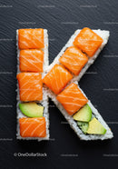 Sushi Rolls Arranged to Form Letter K on Black Slate