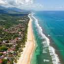 Tropical Beach with Mountains and Coastal Town in Bright Sunny Day