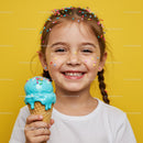 Happy girl enjoying blue ice cream cone with sprinkles