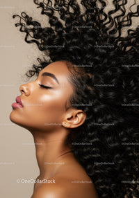 Profile of woman with voluminous curly hair against beige