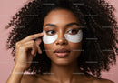 Young Woman Applying Under Eye Patches With Curly Hair