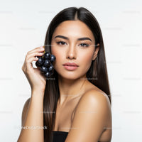 Elegant Woman Holding Fresh Black Grapes with Confident Smile