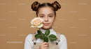 Young Girl Holding a Peach-Colored Rose with Stylish Hair Buns