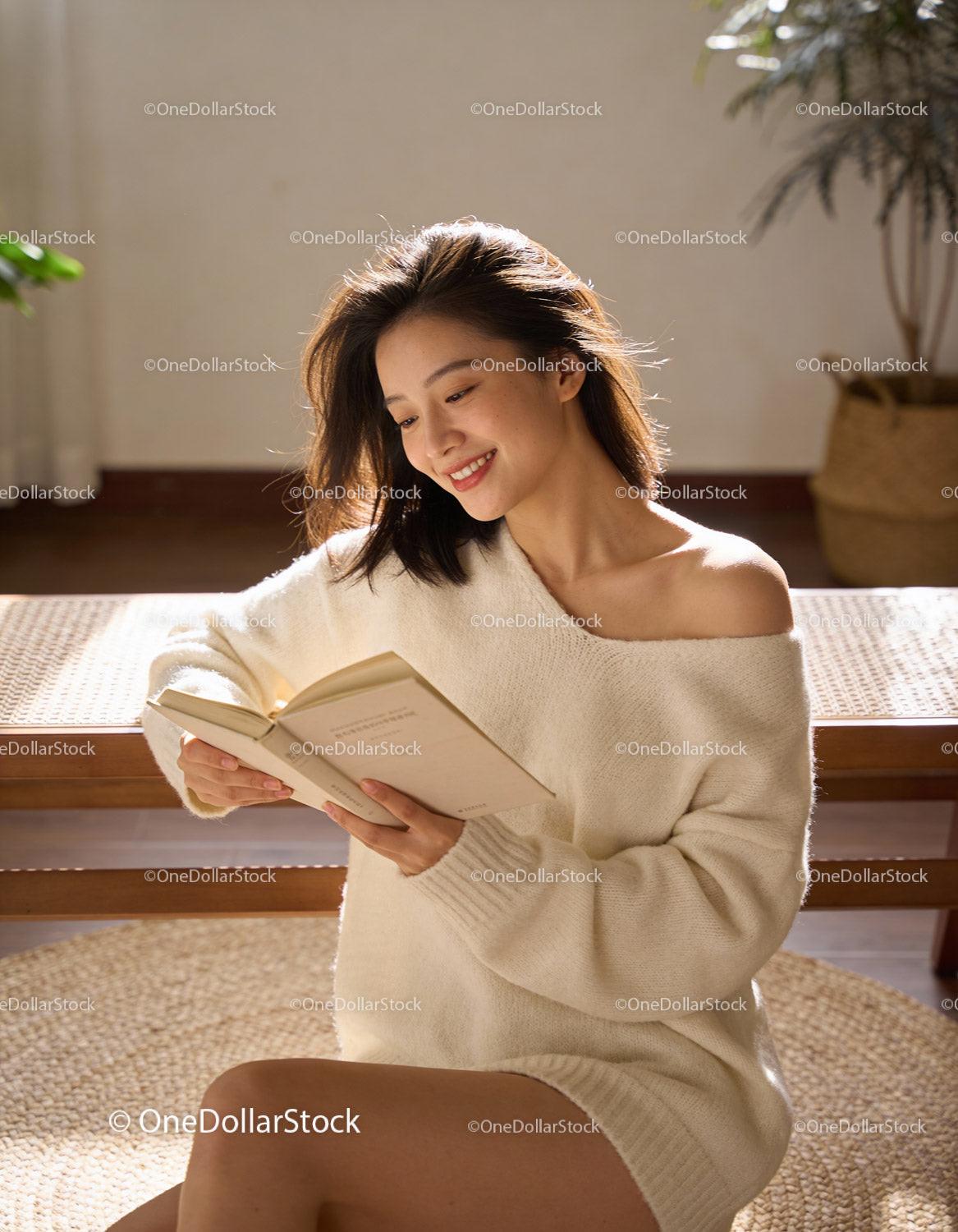 Smiling woman enjoying a book in cozy sunlight