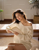 Smiling woman enjoying a book in cozy sunlight