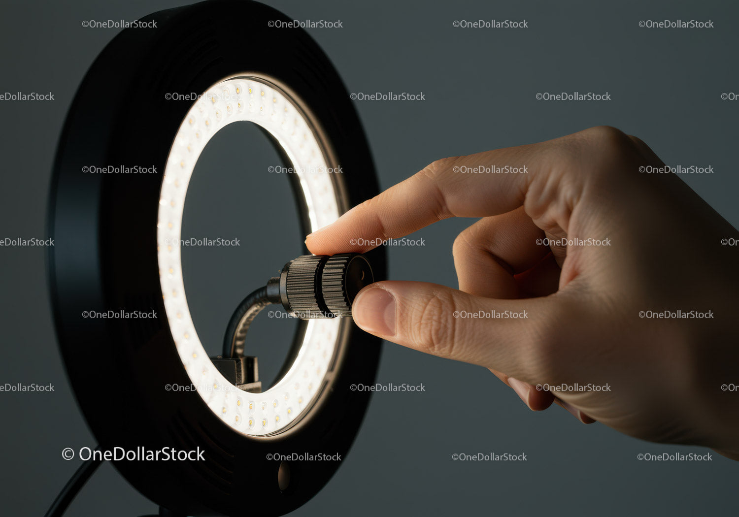 Close-up of Hand Adjusting Bright LED Ring Light for Photography