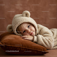 Toddler resting on soft pillow in cozy bear outfit
