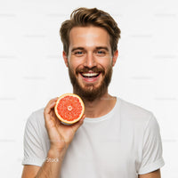 Portrait of Happy Man Holding a Bright Red Grapefruit Slice