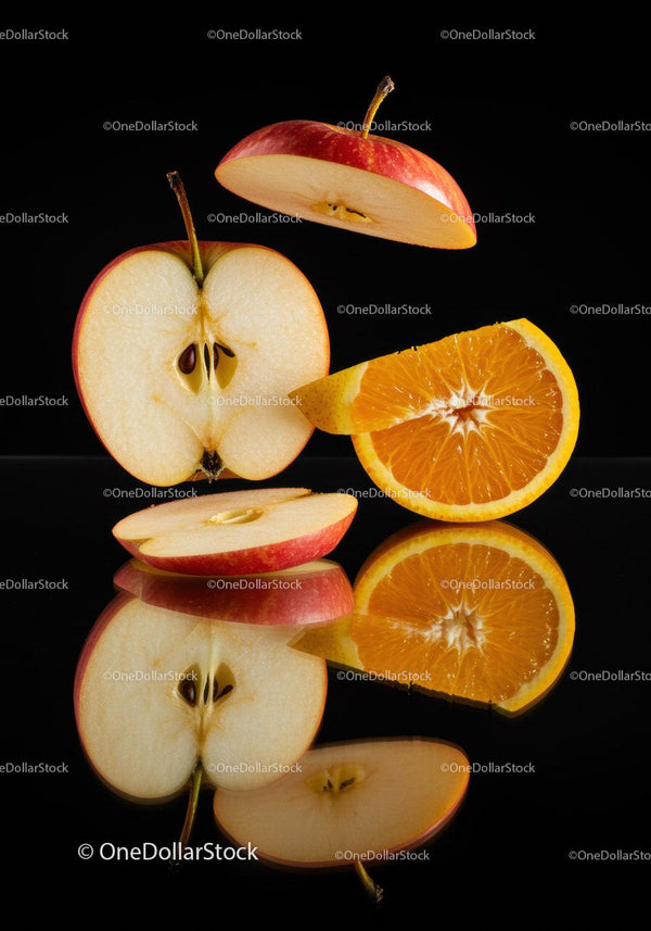 Fresh apple and orange slices with black reflection