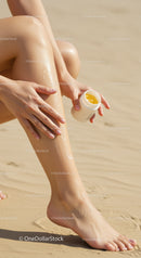 Woman Applying Sunscreen Lotion on Sunlit Beach Skin