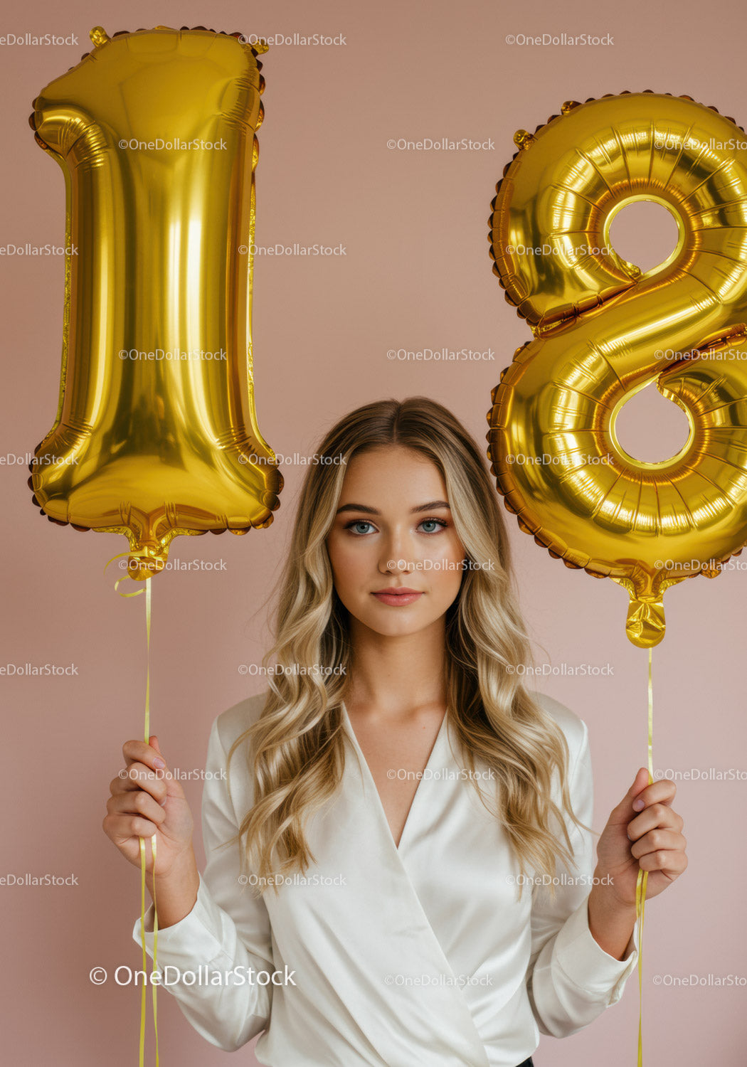 Young woman celebrating 18th birthday with gold balloons
