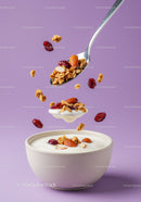 Spoonful of granola and nuts over yogurt bowl