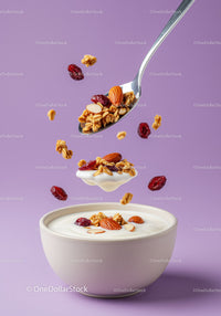 Spoonful of granola and nuts over yogurt bowl