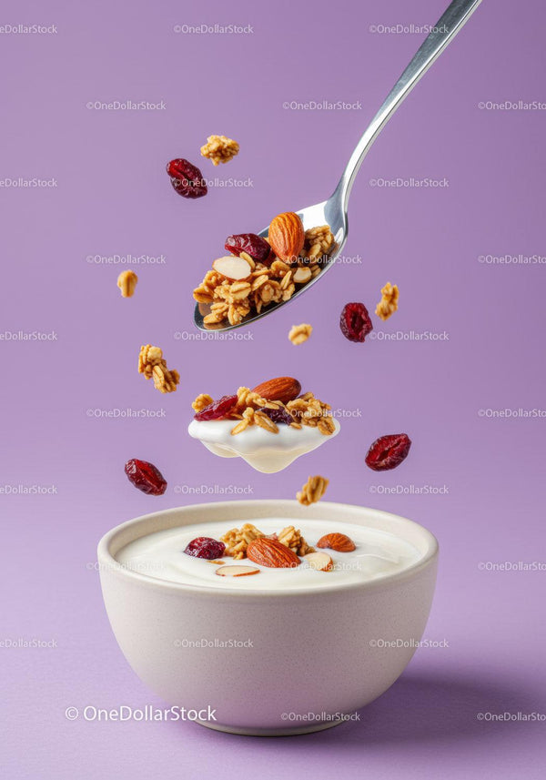 Spoonful of granola and nuts over yogurt bowl