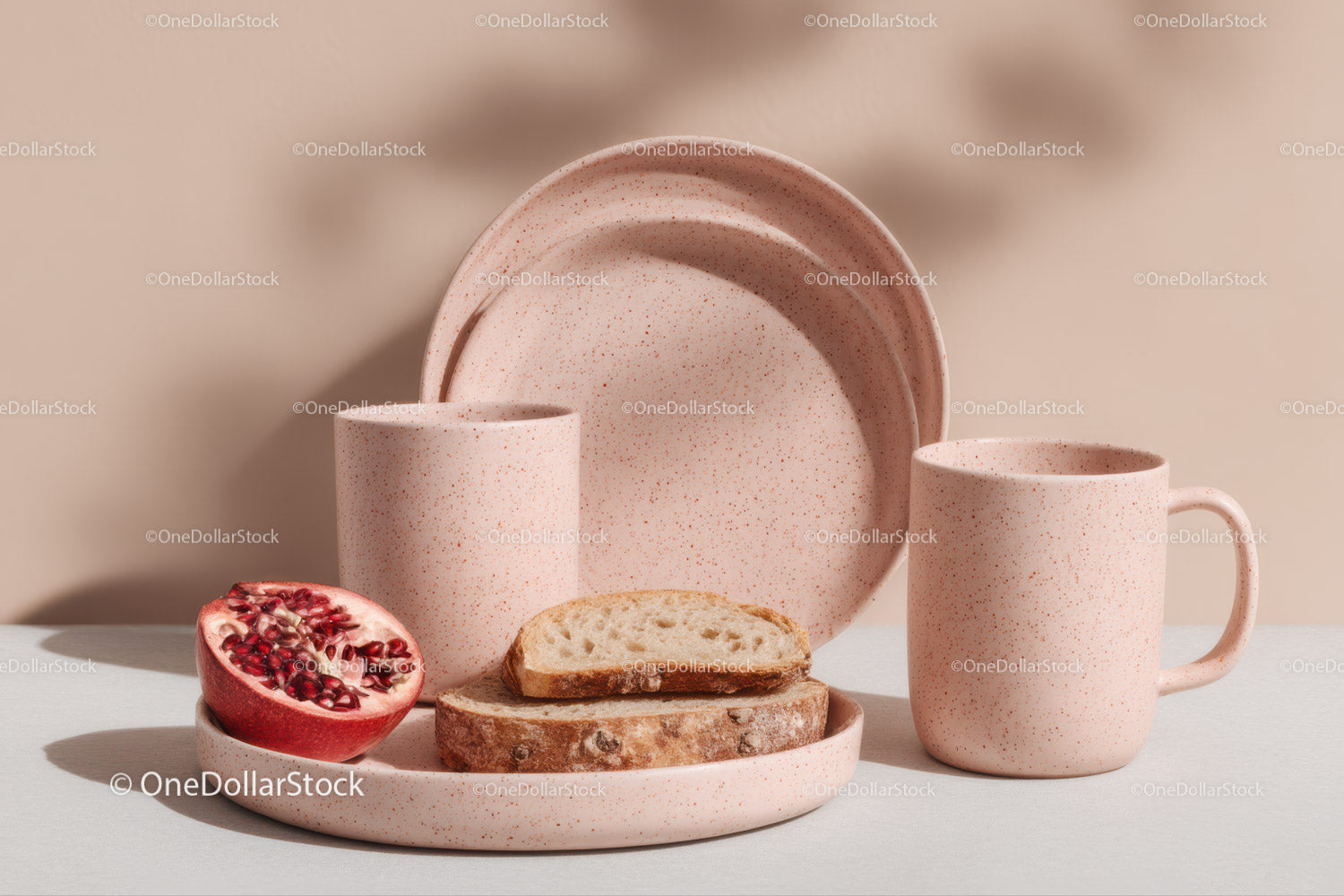 Pink Speckled Ceramic Dishware with Pomegranate and Sliced Bread