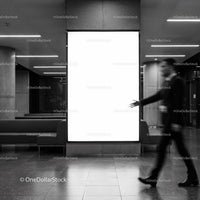 Blurred businessman walking in modern lobby with blank sign
