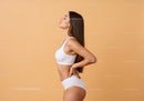 Serene Woman in White Sportswear Against Peach Background
