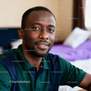 Relaxed young man smiling indoors with natural light