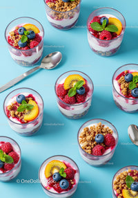 Fresh berry and yogurt parfaits arranged on blue surface
