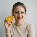 Smiling Woman Holding Fresh Orange Slice Brightens the Day